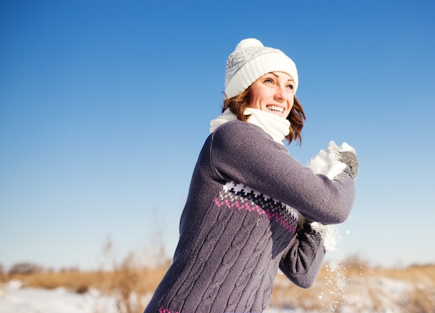 Gelukkig jonge vrouw veel plezier en geniet van verse sneeuw op mooie winterdag