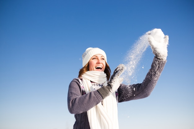 Gelukkig jonge vrouw veel plezier en geniet van verse sneeuw op mooie winterdag