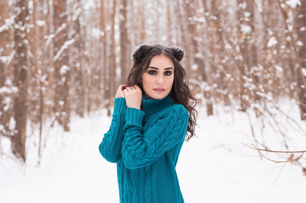 Gelukkig jonge vrouw wandelen in de winter. Mooi meisje in besneeuwde natuur