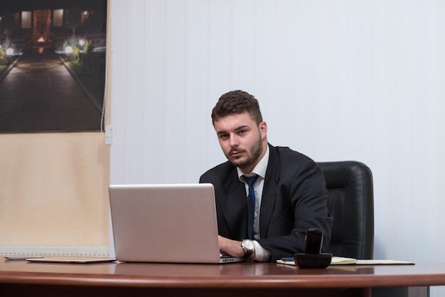 Gelukkig jonge zakenman werken in moderne kantoor op computer