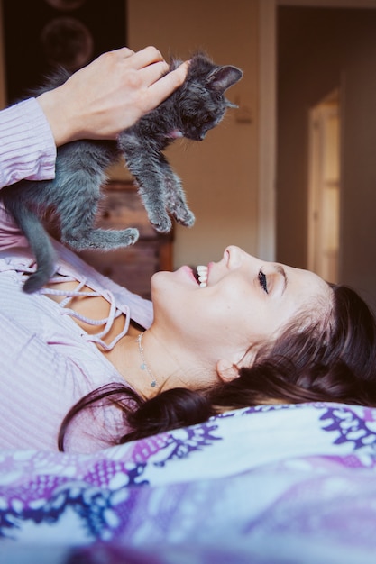 Gelukkig jongedame spelen met een kitten met tedere liefde. dierenliefhebbers levensstijl.