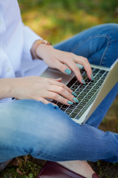 Gelukkig jongedame werkt op een laptop in de natuur