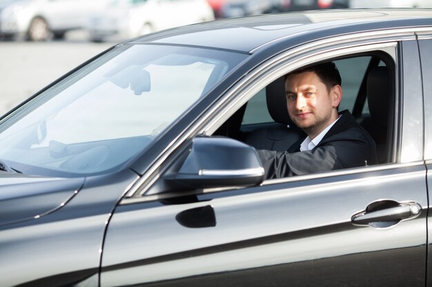 Gelukkig jongeman kocht nieuwe moderne auto.