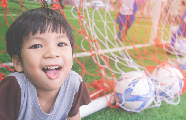 Gelukkig jongetje achter het doel op voetbal trainingsveld