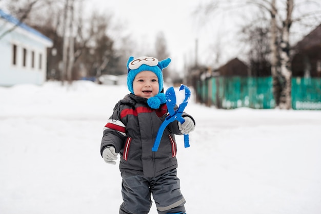 Gelukkig jongetje kind spelen sneeuwballen in de winter