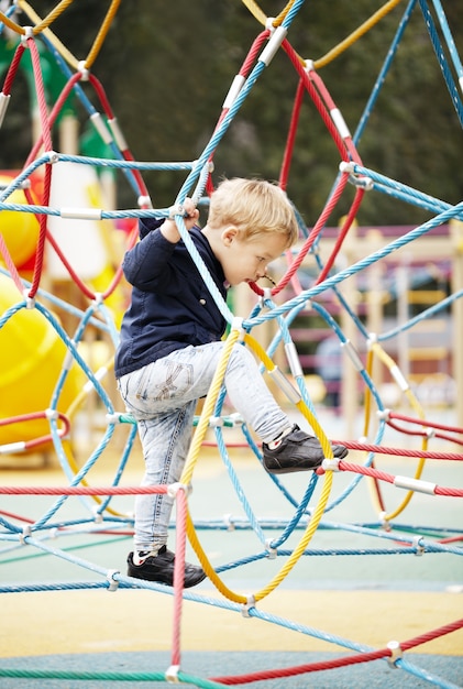 Gelukkig jongetje klimmen op speeltoestellen