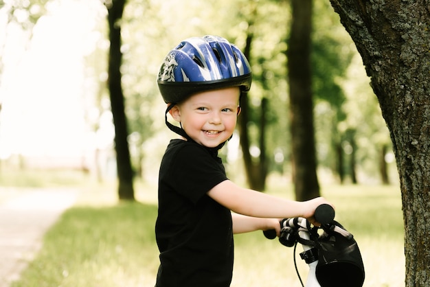 Gelukkig jongetje met een fiets die in het Park loopt