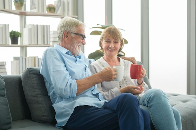 Gelukkig Kaukasisch seniorenpaar drinken koffie in huis, ontspannend en gezondheidszorgconcept.