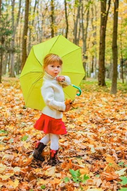 Gelukkig kind buiten spelen in de herfst in het park