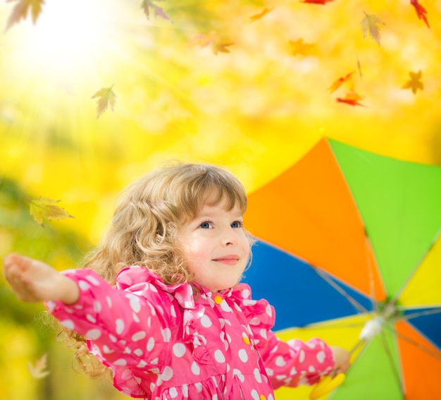 Gelukkig kind buiten spelen in herfst park