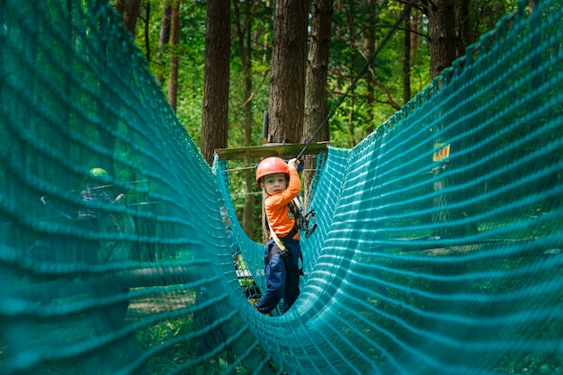 Foto gelukkig kind dat in een beklimmend avonturenpark geniet van