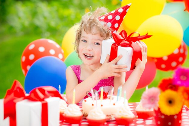 Gelukkig kind dat verjaardag viert kind heeft plezier in de lentetuin