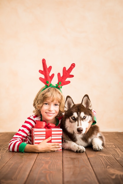 gelukkig kind en hond op kerstavond kind en huisdier gekleed in kerstmuts