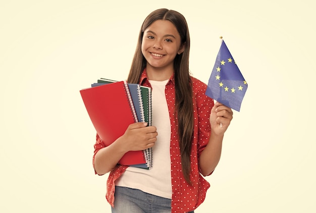 Gelukkig kind houdt de vlag van de europese unie en het schoolboek vast voor het studeren op een witte school