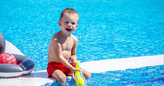 Gelukkig kind in het zwembad spelen met een waterpistool.