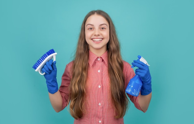 Gelukkig kind in rubberen handschoenen met spuitfles en borstel op blauwe achtergrond