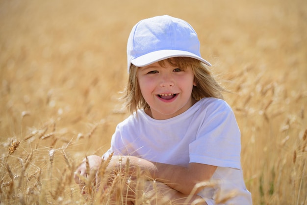 Gelukkig kind in tarweveld buiten schattige lachende jongen die door het tarweveld loopt
