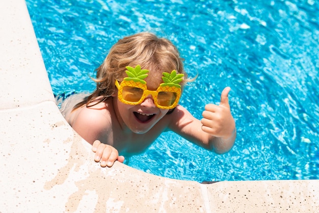 Gelukkig kind in zwembad op zomerdag Kind spelen in tropisch resort Zomervakantie