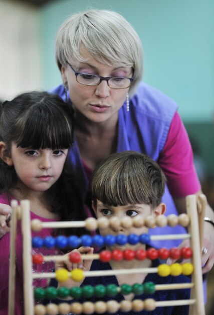 gelukkig kind kinderen groep veel plezier en spelen op de kleuterschool indoor voorschoolse educatie concept met leraar