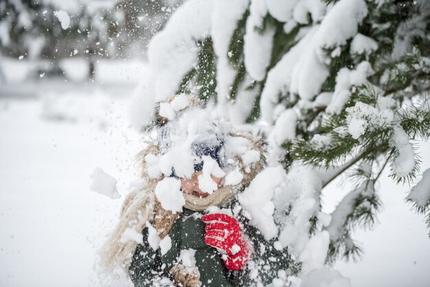 Gelukkig kind meisje plaing met sneeuw op een besneeuwde winterwandeling