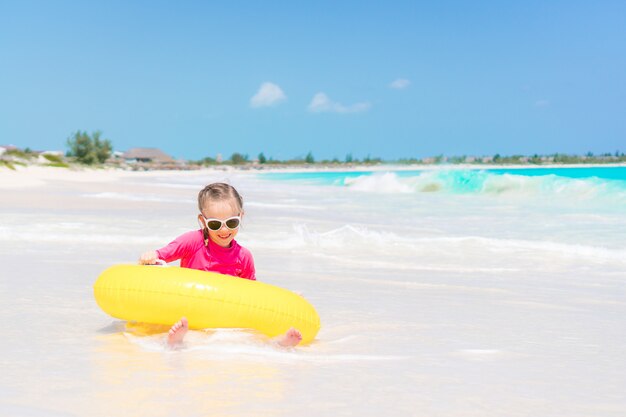 Gelukkig kind met opblaasbare rubberen cirkel plezier op het strand