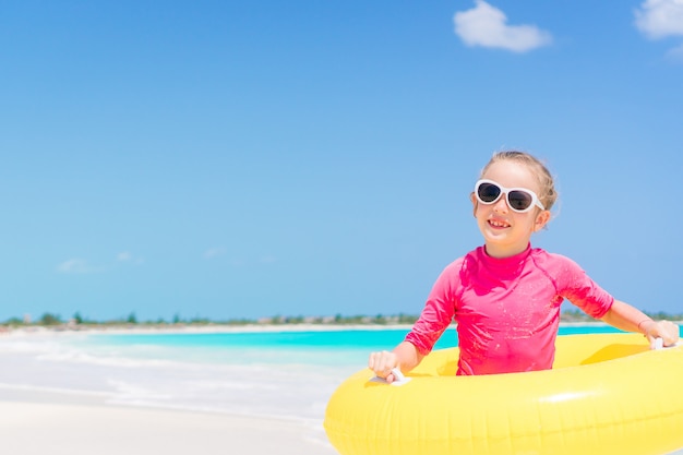 Gelukkig kind met opblaasbare rubberen cirkel plezier op het strand