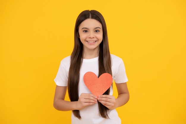 Gelukkig kind met rood hart op gele achtergrond, liefde.