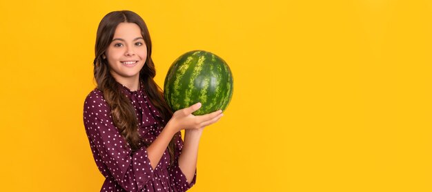 Gelukkig kind met vers rijp watermeloen fruit op gele achtergrond Zomer meisje portret met watermeloen horizontale poster Banner header met kopie ruimte