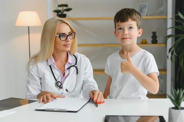 Gelukkig kind naast een dokter in ziekenhuisafdeling