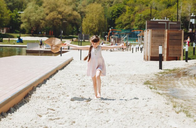 Gelukkig kind op het strandblond meisje rent langs het zand op het strand