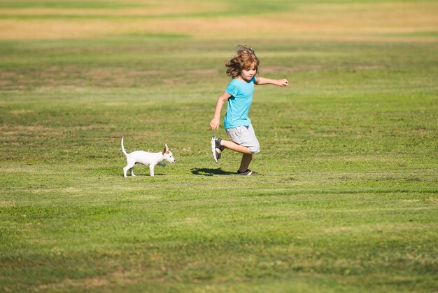 Gelukkig kind rennen met een hond buiten.