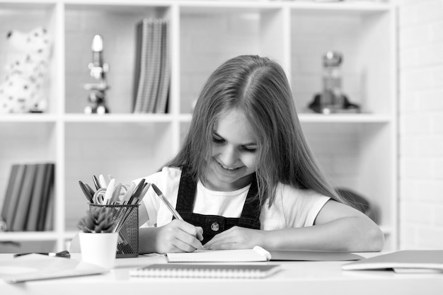 Gelukkig kind schrijven in beurt op school les in klas dragen uniform terug naar school