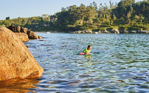 Gelukkig kind spelen in de zee met bodyboard. Kind plezier buitenshuis. Concept van zomervakantie en gezonde levensstijl.