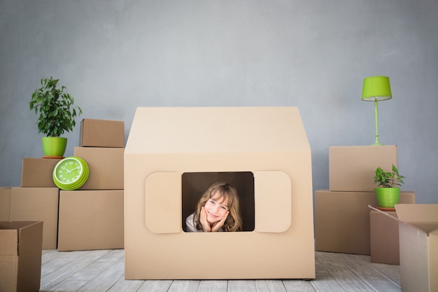 Gelukkig kind spelen in nieuw huis. Verhuisdag en vastgoedconcept