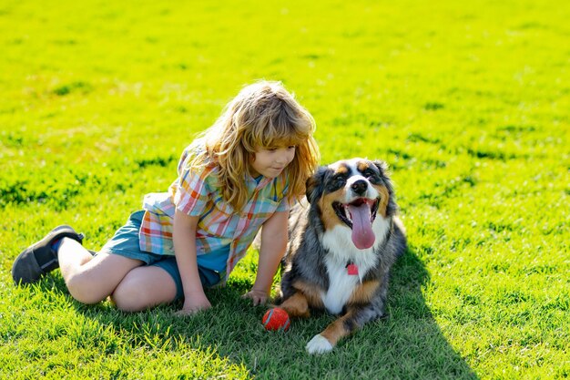 Gelukkig kind spelen met hond in groen grasveld Kind met puppy hondje