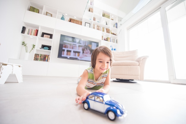 Gelukkig kind spelen met oude auto speelgoed thuis