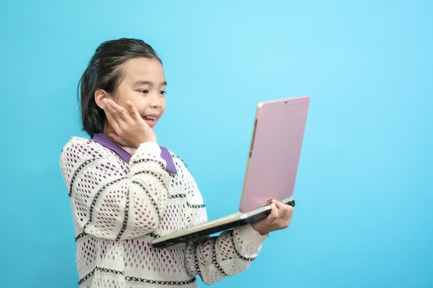 Foto gelukkig kindermeisje, aziatisch kind close-up schattige en vrolijke mensen, houden labtop kijkend en glimlachen