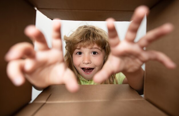 Foto gelukkig kindjaar met kartonnen doos pakket uitpakken van internetwinkel kinderen klant tevreden