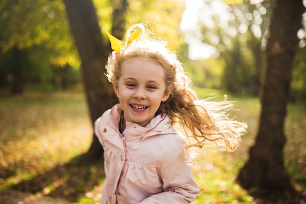 Gelukkig kindmeisje dat plezier heeft in het herfstpark