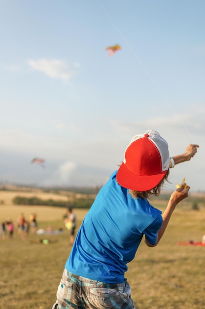 gelukkig kindmeisje met een vlieger op weide in de zomer