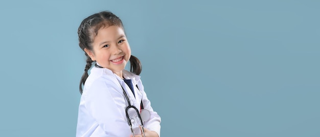 Foto gelukkig klein meisje in doktersjas met stethoscoop. kind spelen. toekomstige bezetting of droombaanconcept. fijne kinderdag.