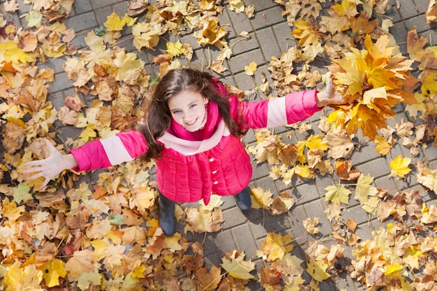 Gelukkig klein meisje met handen omhoog in het bovenaanzicht van het herfstpark