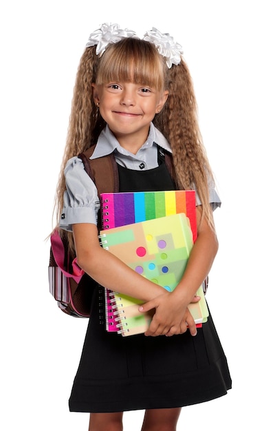 Gelukkig klein meisje met oefenboeken geïsoleerd op witte achtergrond