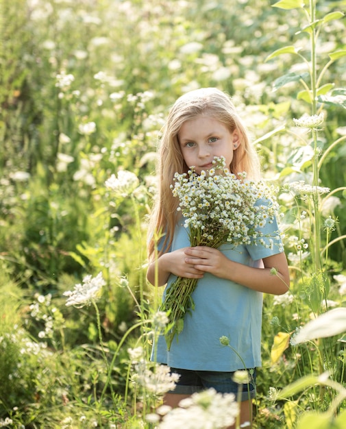 Gelukkig klein meisje op het gebied van zonnebloemen in de zomer.