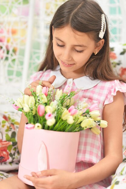 Gelukkig klein meisje poseren met tulpen op schommel