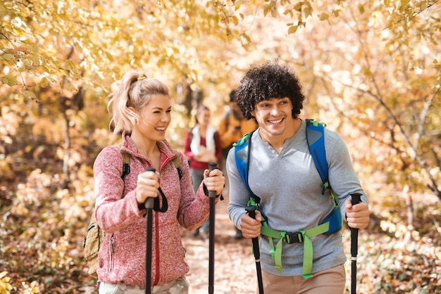 Gelukkig kleine groep wandelaars verkennen van de bossen in de herfst. Op de voorgrond paar wandelen.