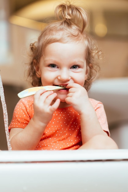 Gelukkig lachend babymeisje haar tanden poetsen in het bad