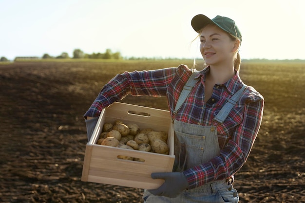 Gelukkig lachend blanke vrouwelijke aardappelboer of tuinman Landbouw voedselproductie oogstconcept