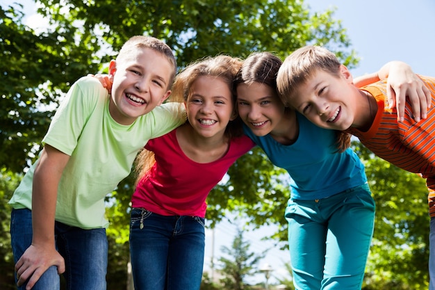 Gelukkig lachend diverse kinderen knuffelen in park