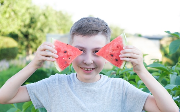 Gelukkig lachend kind dat rijpe watermeloen eet in de zomer